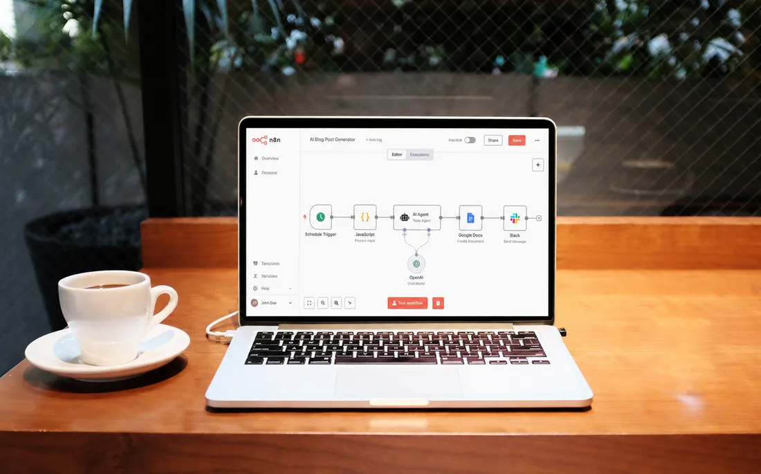 Laptop auf einem Holztisch zeigt einen Automatisierungs-Workflow, daneben eine Kaffeetasse.