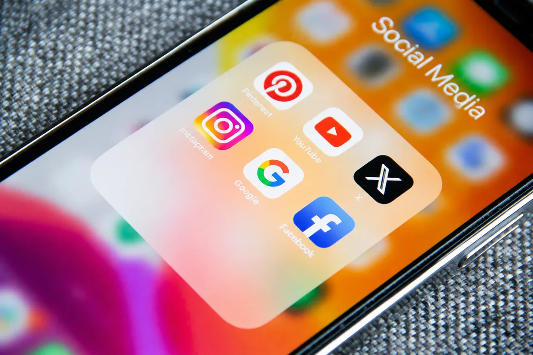 Smartphone mit einem geöffneten Ordner voller Social-Media-Apps.